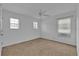 Bright bedroom with neutral walls, carpet, and two windows at 9249 Ivywood St, Clermont, FL 34711