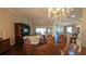 Bright dining room with hardwood floors and a chandelier, open to the living room at 1881 Sassparilla Way, The Villages, FL 32162