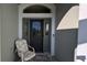 Front entry with door, chair, and welcome mat at 1881 Sassparilla Way, The Villages, FL 32162