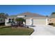 Two-story house with two-car garage and landscaped yard at 1881 Sassparilla Way, The Villages, FL 32162