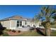 Landscaped yard with seating area next to two-car garage at 1881 Sassparilla Way, The Villages, FL 32162