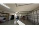 Garage with storage shelving and an open garage door at 1881 Sassparilla Way, The Villages, FL 32162
