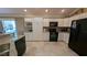 Well-equipped kitchen featuring white cabinets, granite countertops, and black appliances at 1881 Sassparilla Way, The Villages, FL 32162