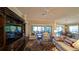 Open living area with hardwood floors, comfortable seating, and access to a patio at 1881 Sassparilla Way, The Villages, FL 32162