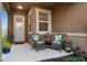 Small front porch with wicker chairs and potted plants at 2676 Spider Lily Ct, Clermont, FL 34711
