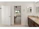 Bathroom with granite countertop, a large mirror, and a view into the bedroom at 3219 Landing Vw, Tavares, FL 32778