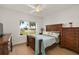 Bright bedroom with a wooden bed frame, dresser, and lake view at 3219 Landing Vw, Tavares, FL 32778