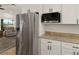 Stainless steel refrigerator and microwave in a kitchen with granite countertops at 3219 Landing Vw, Tavares, FL 32778