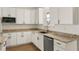 White kitchen cabinetry with granite countertops and stainless steel appliances at 3219 Landing Vw, Tavares, FL 32778