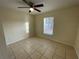 Sunny bedroom, tile floors, and a ceiling fan at 61 Fir Dr, Ocala, FL 34472