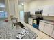 Modern kitchen with white cabinets, granite counters, and stainless steel appliances at 61 Fir Dr, Ocala, FL 34472