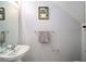 Small, updated half bathroom with a pedestal sink and modern fixtures at 4904 Sw 45Th St, Ocala, FL 34474