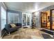 Sunroom with stone flooring, couch and access to backyard at 12359 Ne Highway 314, Silver Springs, FL 34488