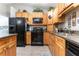 Modern kitchen with wood cabinets, granite countertops and black appliances at 12359 Ne Highway 314, Silver Springs, FL 34488
