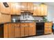 Modern kitchen with wood cabinets, granite countertops and black appliances at 12359 Ne Highway 314, Silver Springs, FL 34488