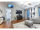 Bright living room with hardwood floors, comfy seating, and a large TV at 12359 Ne Highway 314, Silver Springs, FL 34488