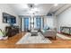 Spacious living room with hardwood floors and gray couch at 12359 Ne Highway 314, Silver Springs, FL 34488