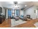 Living room with hardwood floors, gray couch, and large TV at 12359 Ne Highway 314, Silver Springs, FL 34488