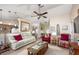 Living room with off-white couch, red chairs, and large TV at 5 Hemlock Terrace Pass, Ocala, FL 34472