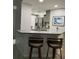 Kitchen with granite countertop and breakfast bar with two stools at 2625 S Atlantic Ave # 9Ne, Daytona Beach, FL 32118