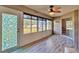 Bright sunroom features wood-look floors, ceiling fan, and view of backyard at 3290 Se 53Rd Ct, Ocala, FL 34480