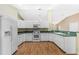 U-shaped kitchen with white cabinets and green countertops at 9573 Sw 53Rd Cir, Ocala, FL 34476