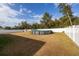 Backyard with above-ground pool and a white fence on a partly cloudy day at 15761 Sw 23Rd Avenue Rd, Ocala, FL 34473