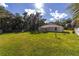 Sunny backyard with a large grassy area and a partially visible school bus at 13589 Se 100Th Ave, Belleview, FL 34420