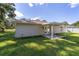 Backyard view of the house with a covered patio and grassy area at 13589 Se 100Th Ave, Belleview, FL 34420