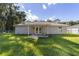 Backyard view of the house with a covered patio and fenced yard at 13589 Se 100Th Ave, Belleview, FL 34420