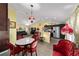 Open dining area with marble table, red chairs, and a view into the living room at 13589 Se 100Th Ave, Belleview, FL 34420