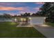 One-story house with attached garage, landscaped yard, and a lovely sunset at 13589 Se 100Th Ave, Belleview, FL 34420