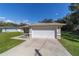 Single-story house with a white garage door and a neat lawn at 13589 Se 100Th Ave, Belleview, FL 34420