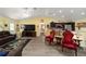 Open living space with hardwood floors, red accent chairs, and a view of the kitchen at 13589 Se 100Th Ave, Belleview, FL 34420
