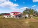 Aerial view of a two-story house with a red roof, pool, and large backyard at 20690 Sw 36Th St, Dunnellon, FL 34431