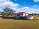 Two-story house with red metal roof, large yard, and scenic background at 20690 Sw 36Th St, Dunnellon, FL 34431