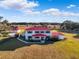 Aerial view of a two-story house with red roof and detached garage at 20690 Sw 36Th St, Dunnellon, FL 34431