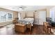 Bedroom with hardwood floors, a wooden four-poster bed, and a small workspace at 20690 Sw 36Th St, Dunnellon, FL 34431