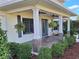 Covered porch with tile flooring and lush landscaping at 20690 Sw 36Th St, Dunnellon, FL 34431