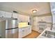 Kitchen with white cabinets, tile countertops, and stainless steel refrigerator at 103 13Th Se St, Winter Haven, FL 33880