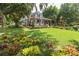 Two story home with wraparound porch, lush landscaping, and large yard at 350 E Park Ave, Lake Wales, FL 33853