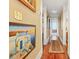 Long hallway with hardwood floors and framed artwork on the walls at 350 E Park Ave, Lake Wales, FL 33853