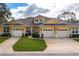 Two-story yellow home with three-car garage and landscaping at 3017 Mission Lakes Dr, Lakeland, FL 33803