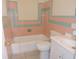 Retro bathroom with pink and green tile, tub, and toilet at 5016 Washington St, Lake Wales, FL 33859