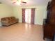 Living room with tiled floors, a sofa, and a TV stand at 914 Oxford Way, Lake Wales, FL 33853