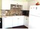 White kitchen with granite countertops and tile backsplash at 914 Oxford Way, Lake Wales, FL 33853