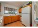 Kitchen with wood cabinets, double sink, and view to outside at 8203 Village Dr # 8203, Lake Wales, FL 33898