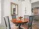 Round wooden dining table with four chairs, decorative bowl, and mirror at 341 Lake Suzanne Dr, Lake Wales, FL 33859