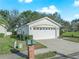 White single-car garage with landscaping and brick mailbox at 341 Lake Suzanne Dr, Lake Wales, FL 33859