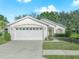 One-story home with white exterior, two-car garage, and landscaped lawn at 341 Lake Suzanne Dr, Lake Wales, FL 33859